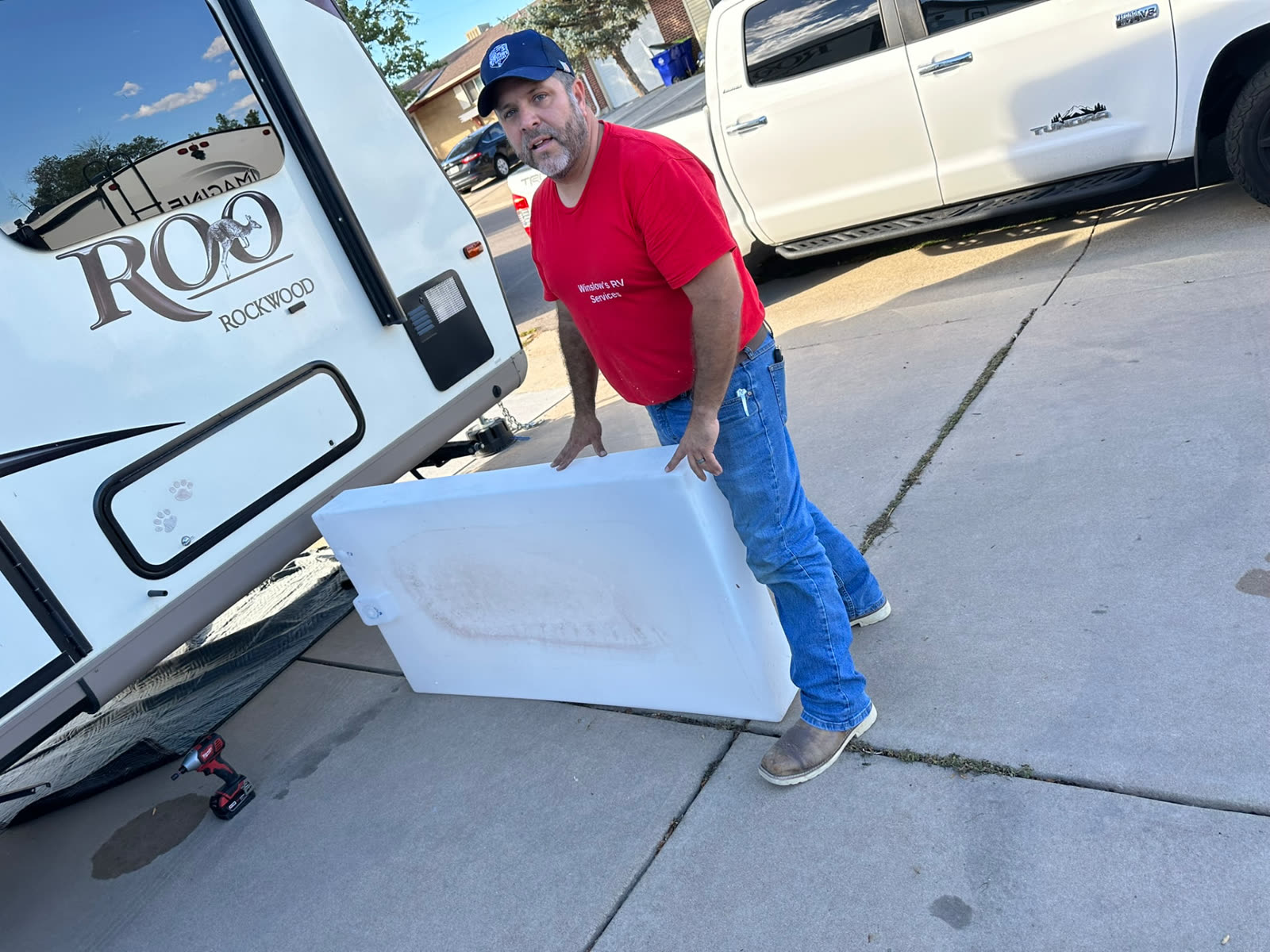 Ken Winslow beside a travel trailer with a removed freshwater tank
