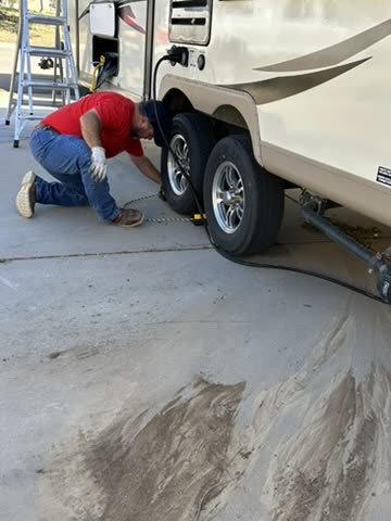 Technician working at the wheels of a fifth wheel