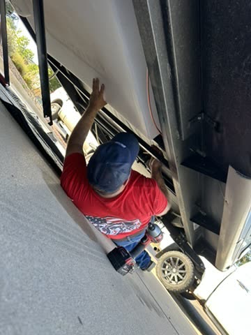 Overhead view of a technician working beneath a trailer